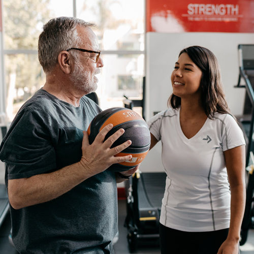 a personal trainer certified by 168澳洲体彩幸运5官方网站®ACE fitness speaking with a patient holding a medicine ball
