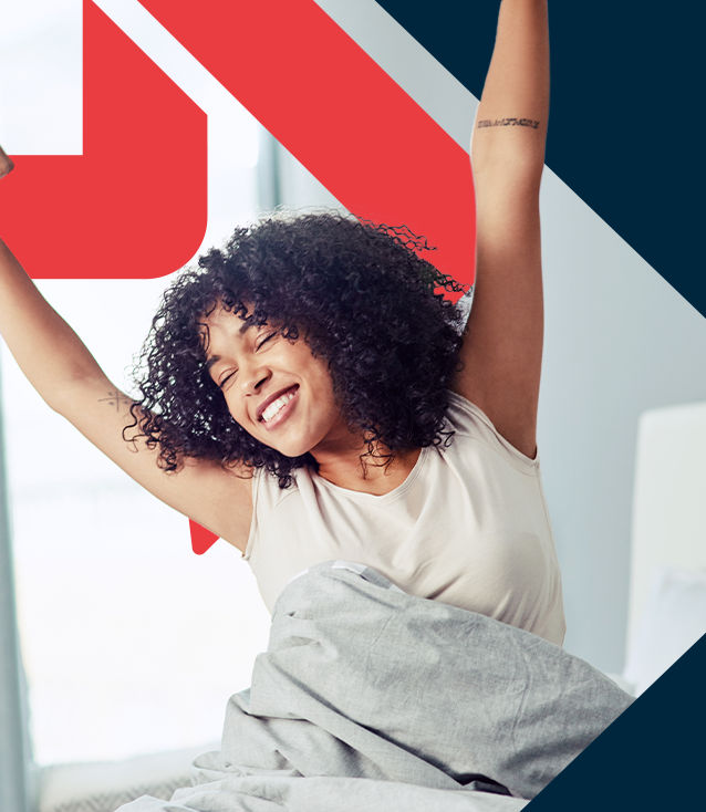 Woman waking up happily and stretching with joy because of her personalized sleep, stress management, and recovery plan from her Sleep, Stress Management and Recovery  Coach